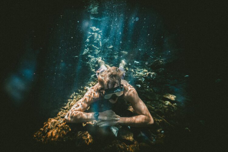 A diver looking at fish, wearing a TAG Heuer Watch